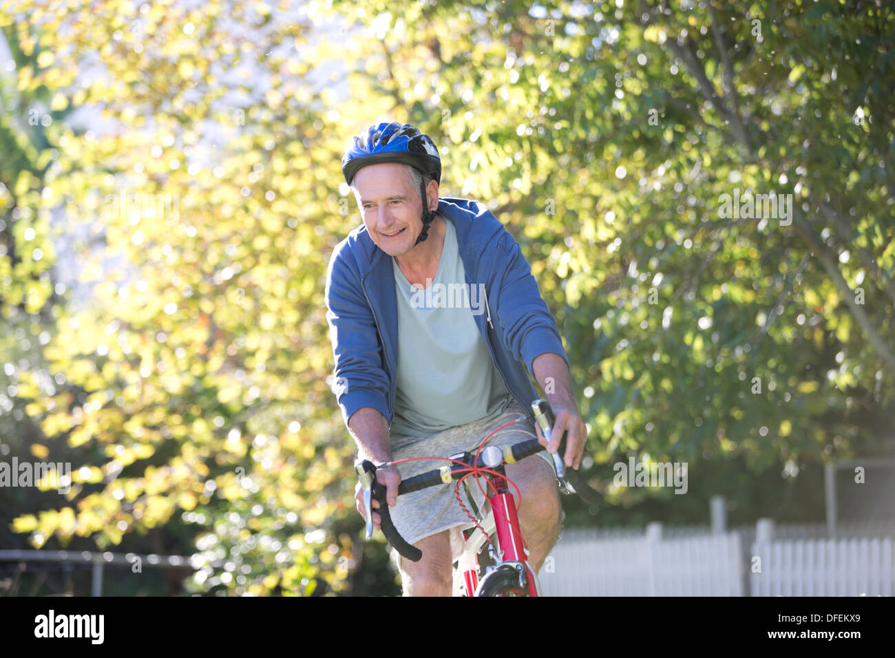 Senior man riding bicycle in park Banque D'Images