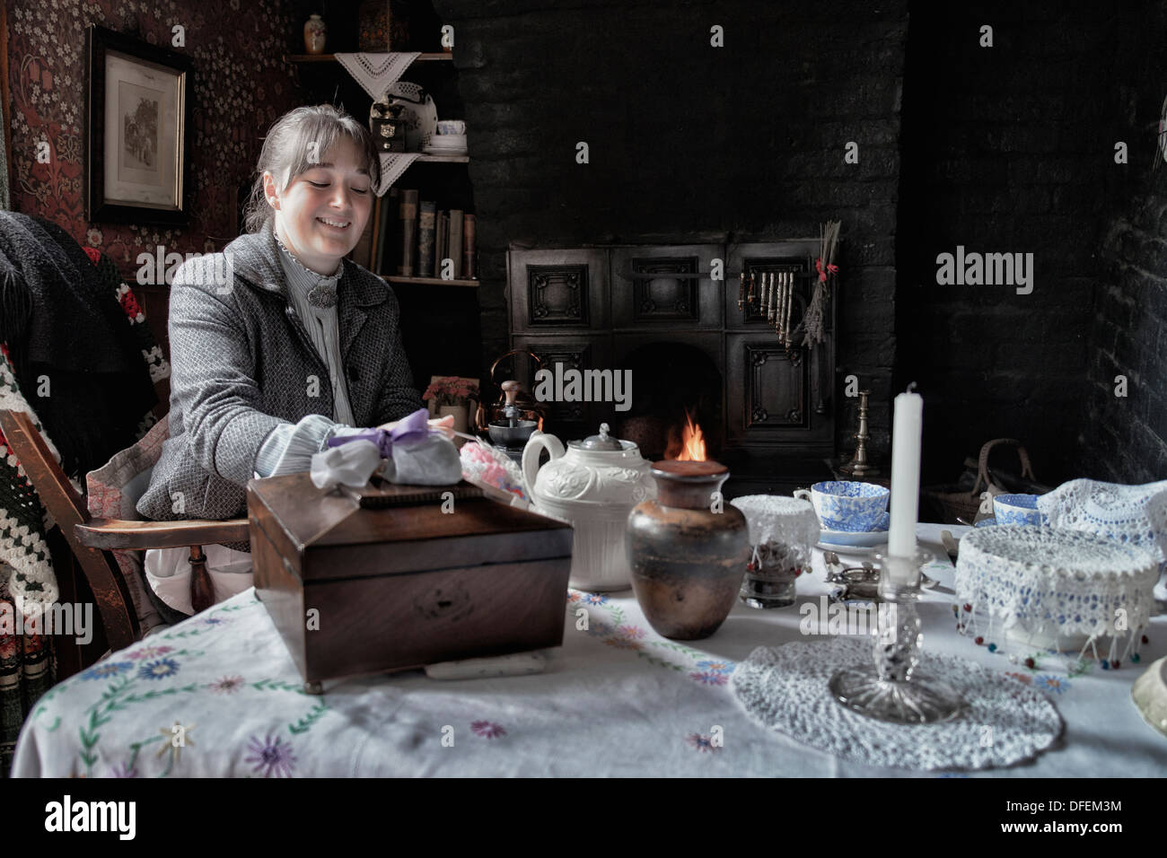 Une employée féminine du Black Country Living Museum accueille des visiteurs dans une maison de type chalet préservée des années 1800/début 1900. Salle de l'époque victorienne Angleterre Banque D'Images