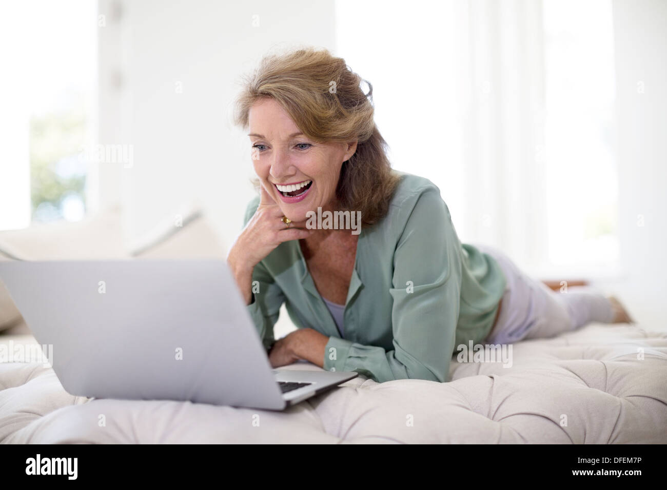 Senior woman using laptop in living room Banque D'Images