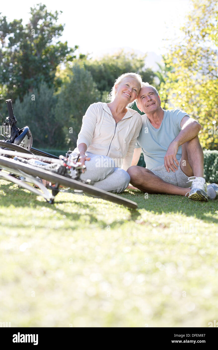 Senior couple sitting in park with bicycles Banque D'Images