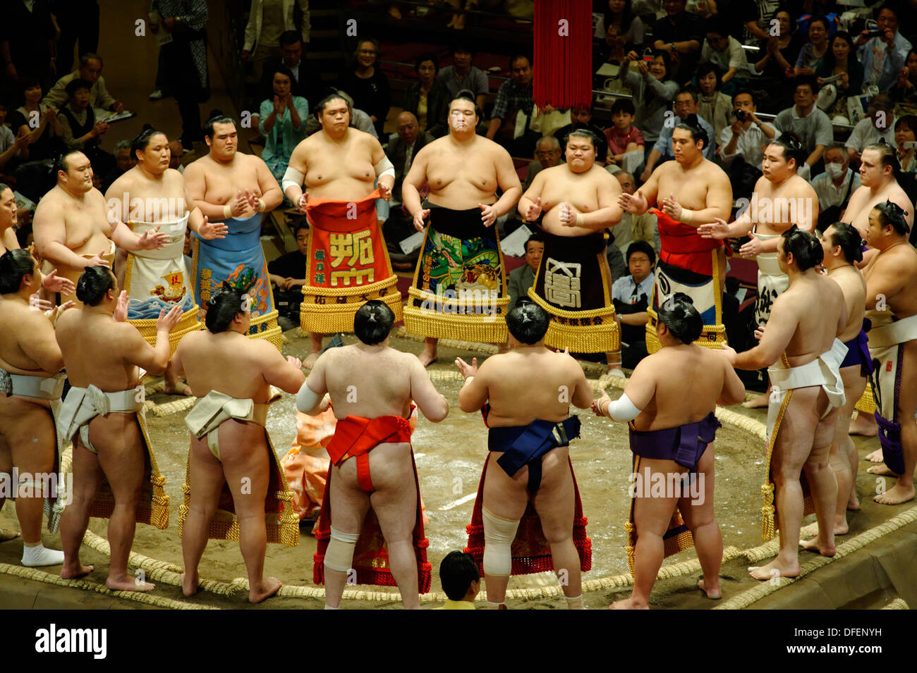 Les lutteurs de sumo dans leur tablier de cérémonie décoré de kesho mawashi  rassembler en cercle autour de l'arbitre gyoji dans le Dohyo-iri Photo  Stock - Alamy