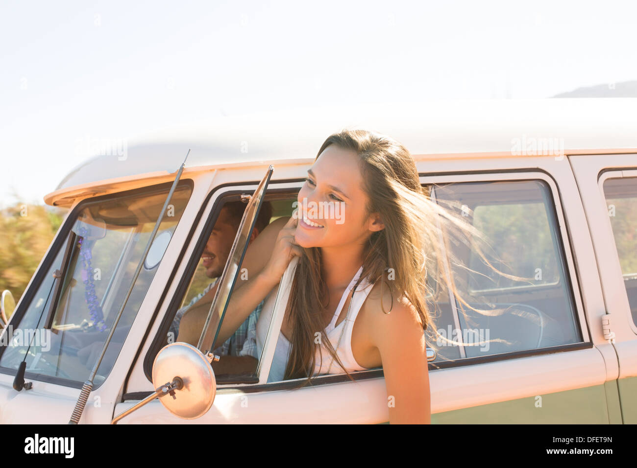 Woman leaning head out fenêtre camping-car Banque D'Images