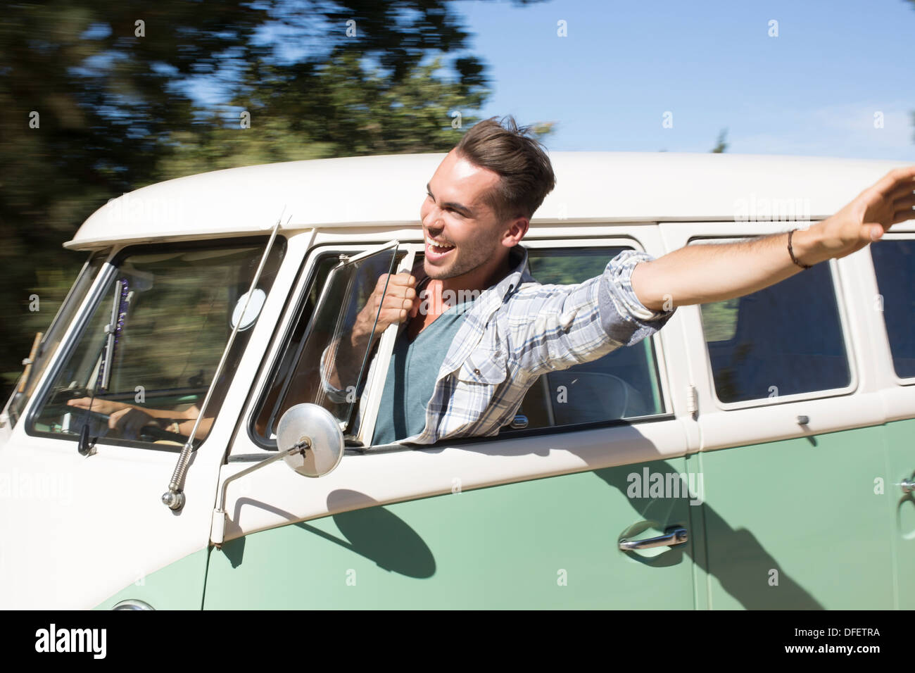 Man leaning head out fenêtre camping-car Banque D'Images