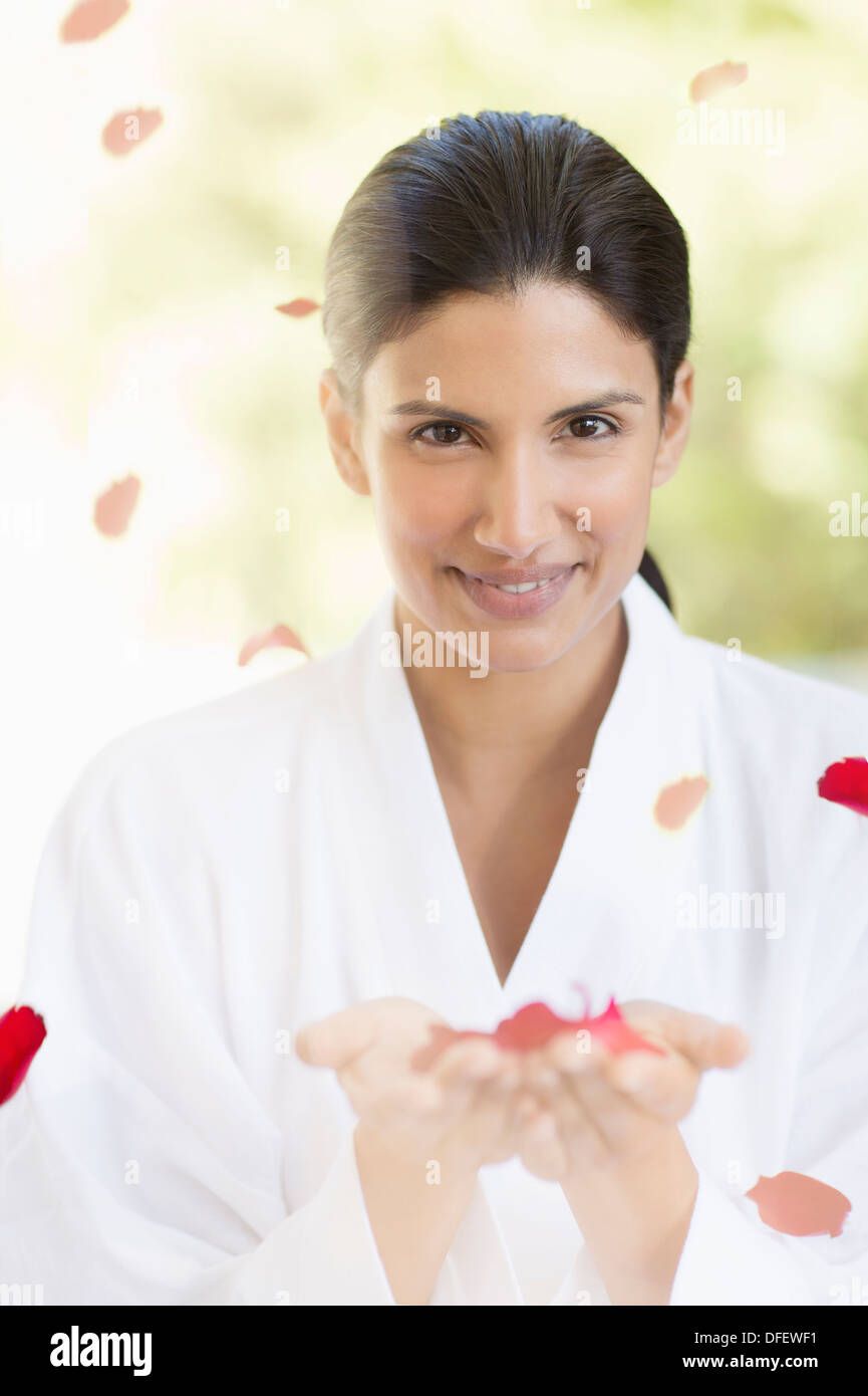 Portrait of smiling woman holding rose petals Banque D'Images