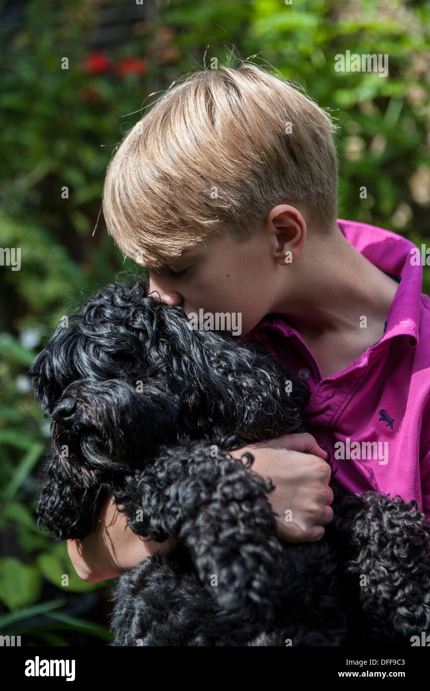 Un jeune garçon embrasse son chien Banque D'Images