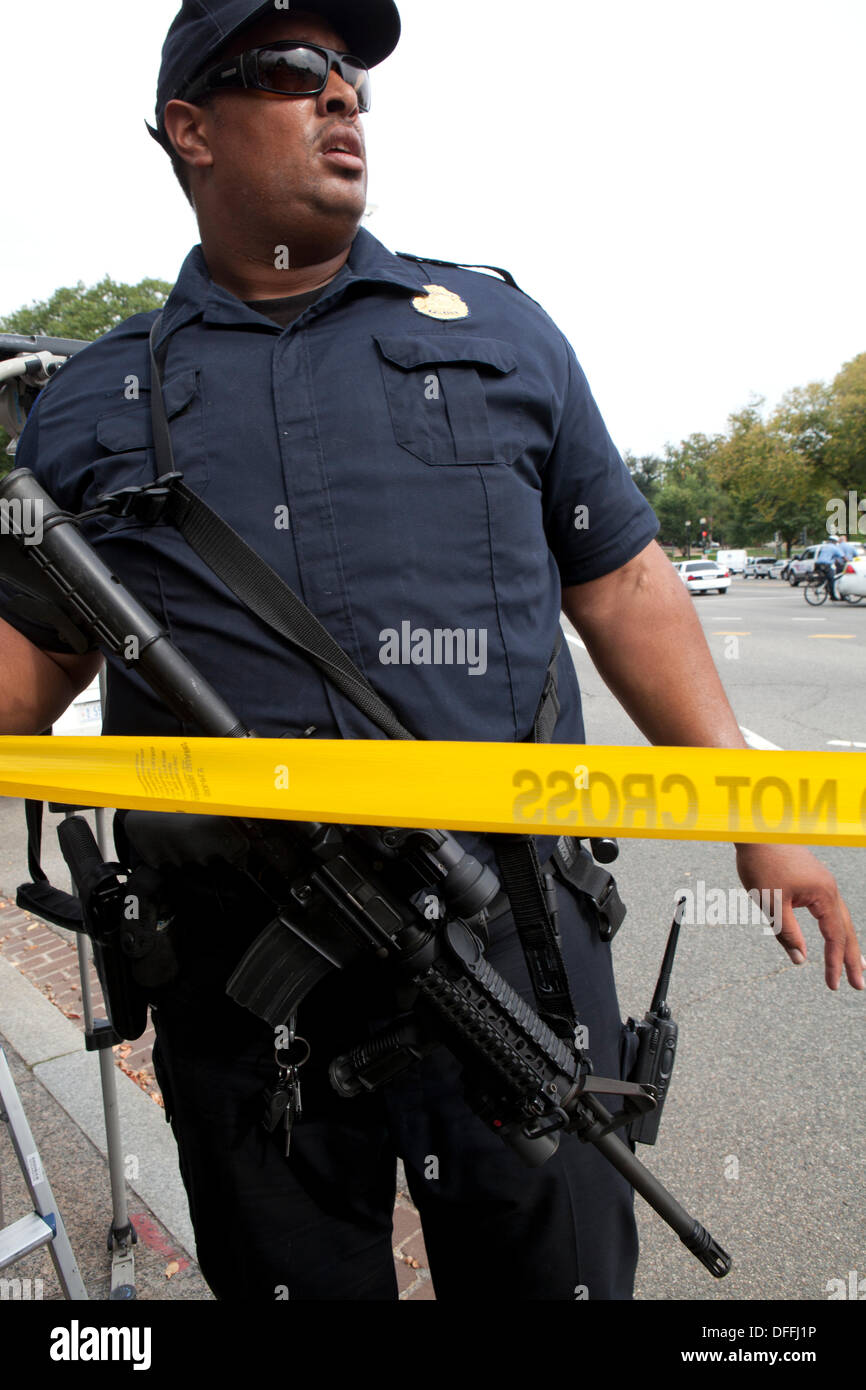 Policier portant un fusil semi-automatique La mise en place de la police tape sur la scène de crime - Washington, DC USA Banque D'Images