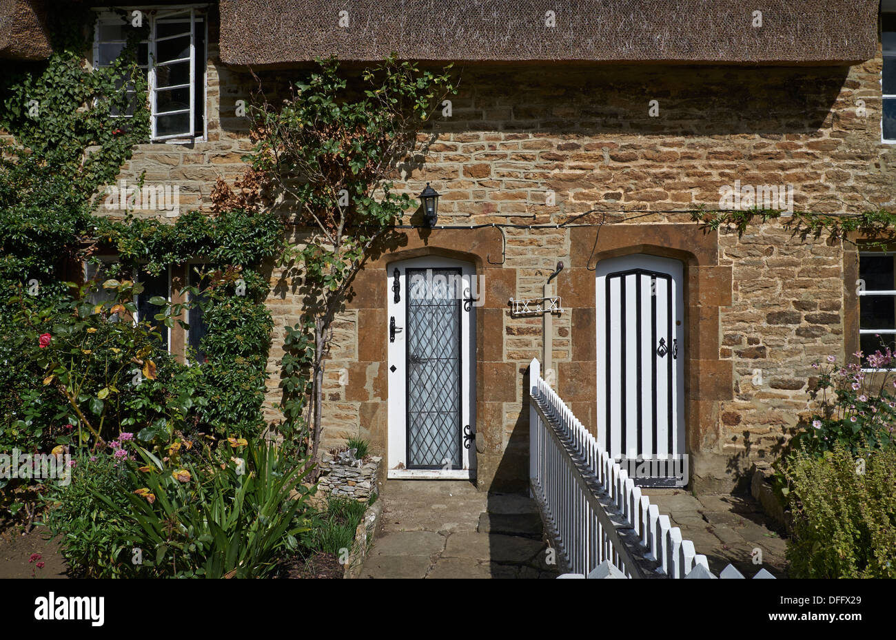 Cottage Royaume-Uni. Terrasse traditionnelle Cotswold période de pierre de campagne anglaise extérieur et portes d'entrée ravissantes. Angleterre Royaume-Uni Banque D'Images
