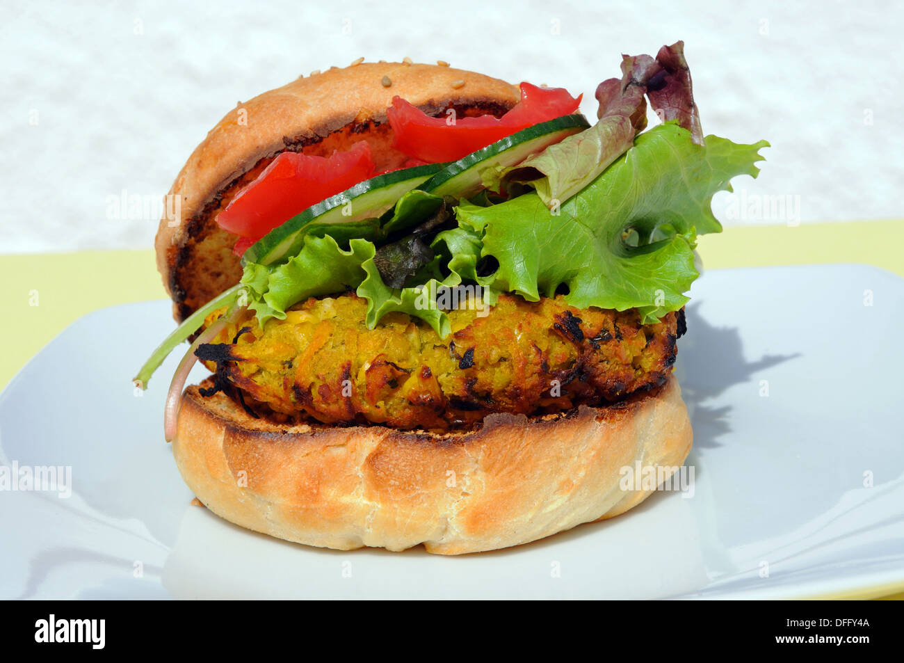 Pois chiches, maïs doux végétarien et carotte burger avec de la salade dans un pain aux graines de sésame. Banque D'Images