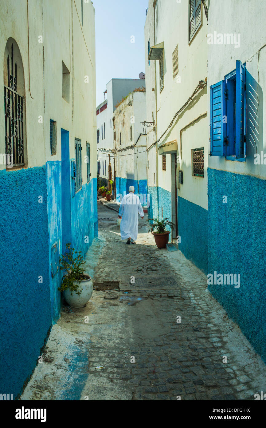 Dans l'homme islamique djellaba blanc marche sur une rue marocaine Banque D'Images
