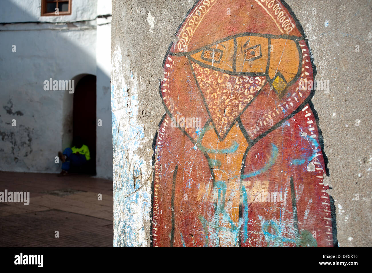 Le Graffiti représentant un mauvais garçon. Dans l'arrière-plan, un employé municipal chargé de nettoyer les rues se repose ( Maroc) Banque D'Images