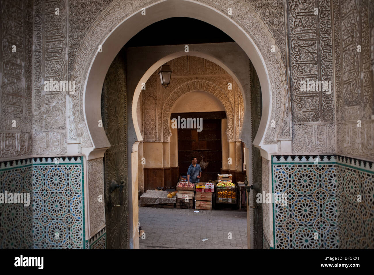 Entrée de la Medersa Bou Inania ( un ancien de l'école islamique). Dans l'arrière-plan, un vendeur de fruits ( Maroc) Banque D'Images