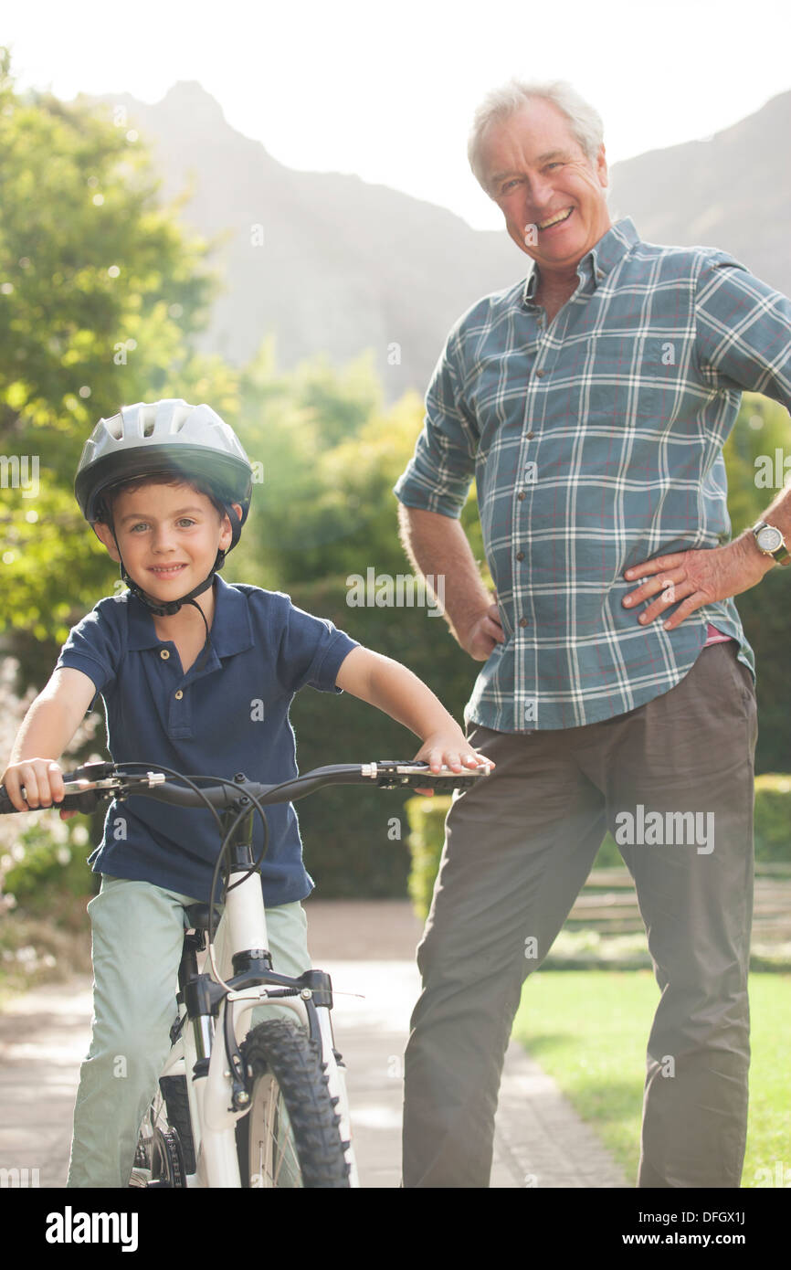 Older Man teaching grandson to ride bicycle Banque D'Images