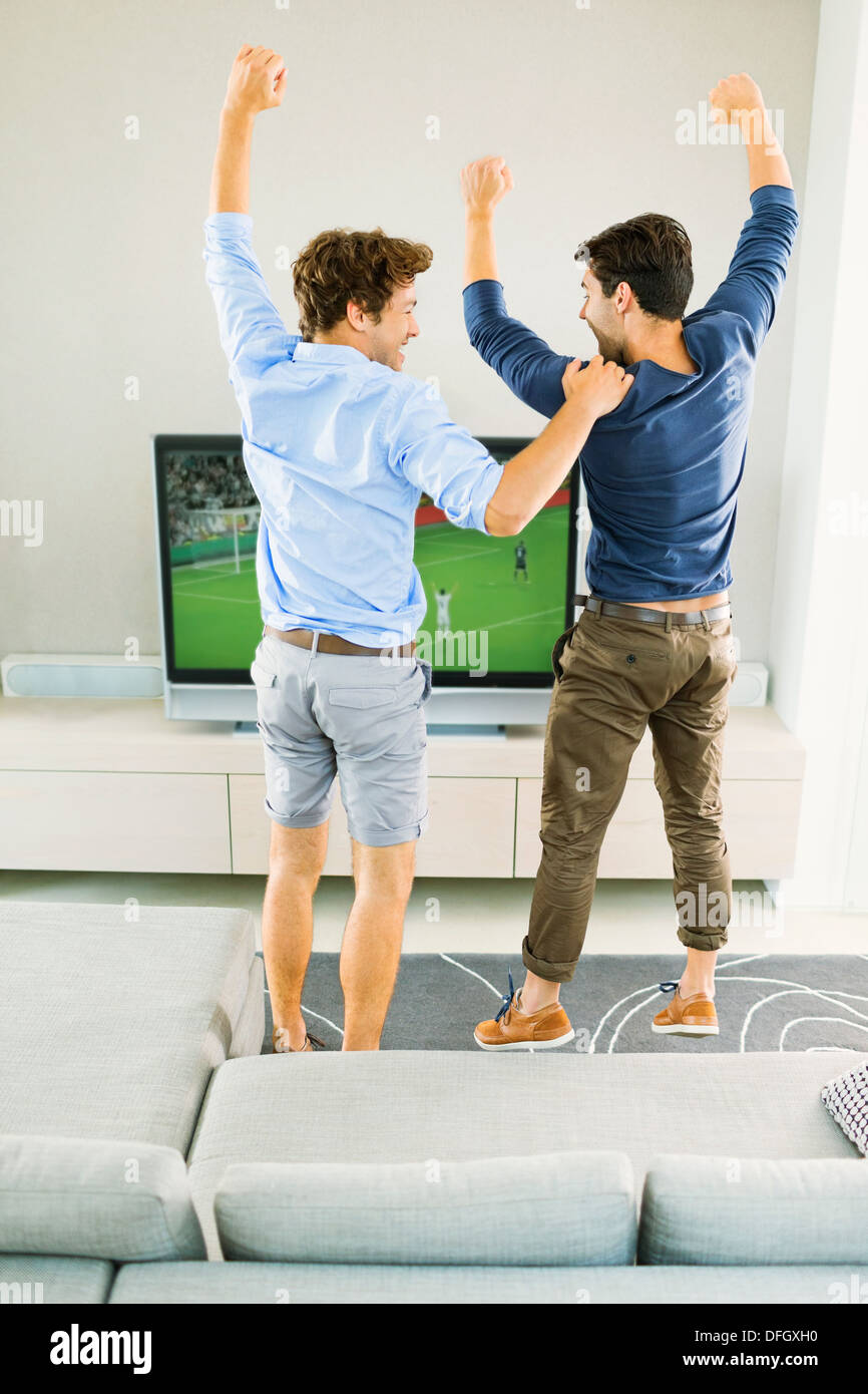 Les hommes acclamations et regarder le soccer game Banque D'Images