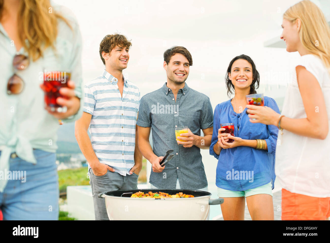 Friends enjoying drinks at barbecue Banque D'Images