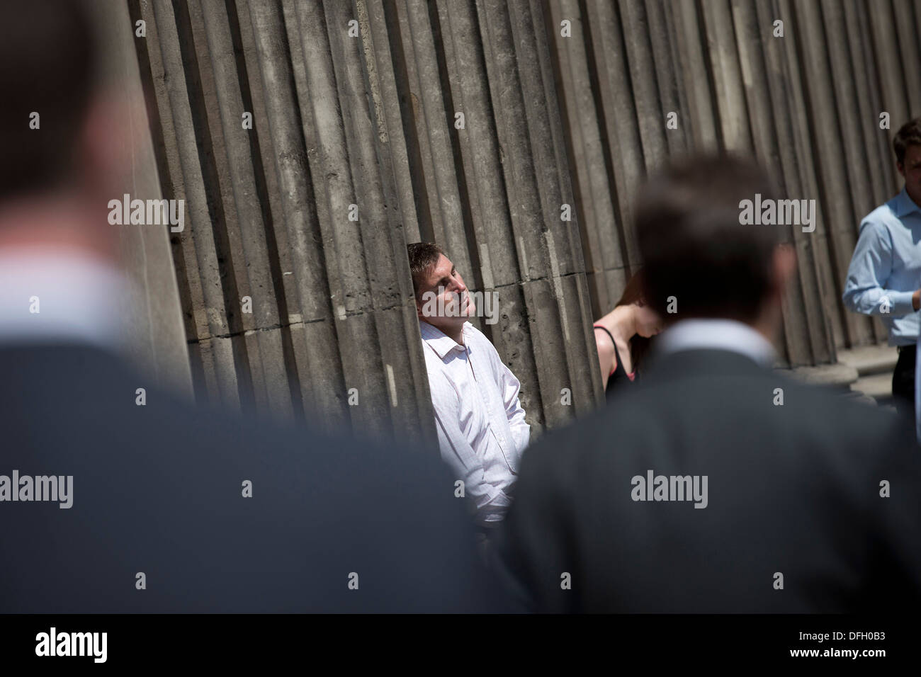 Un homme dort dans le soleil par temps chaud appuyé contre la banque d'Angleterre à Londres le 9 juillet 2013. Banque D'Images