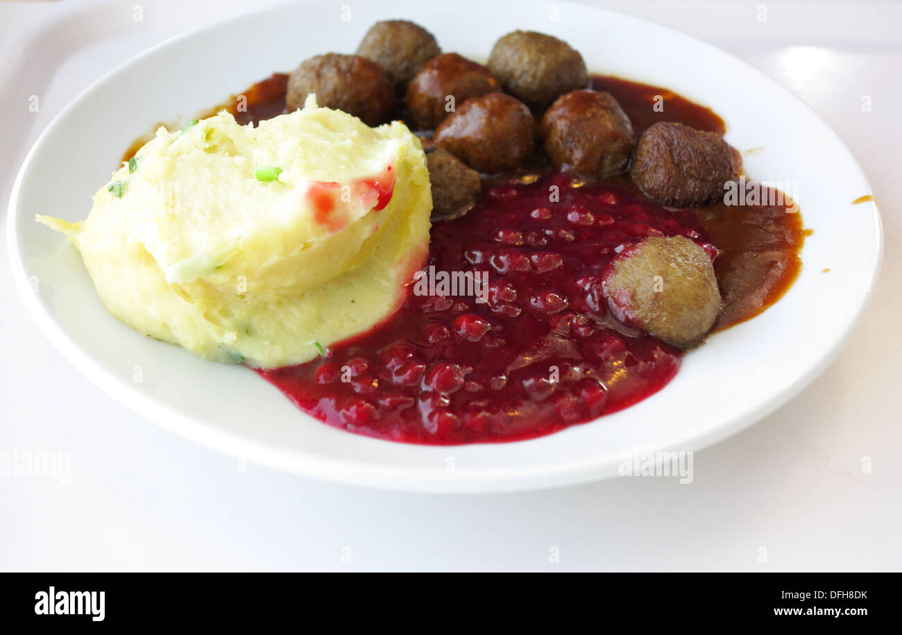 On mange de la nourriture. Boulettes de pommes de terre suédoise cranberry sur le plat. Une cuisine traditionnelle scandinave. Banque D'Images