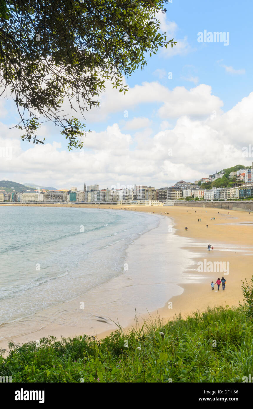 Les marcheurs de la plage au printemps sur la Playa de la Concha, San Sebastian, Espagne San Sebastian, Espagne Banque D'Images