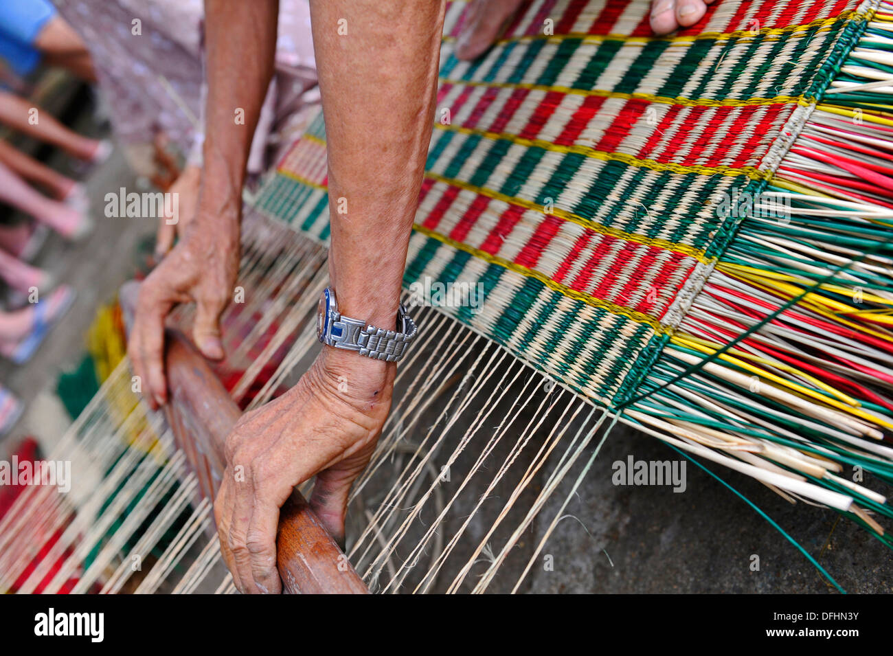 Personnes âgées faisant main vietnamiens reed colorés de tapis. Banque D'Images