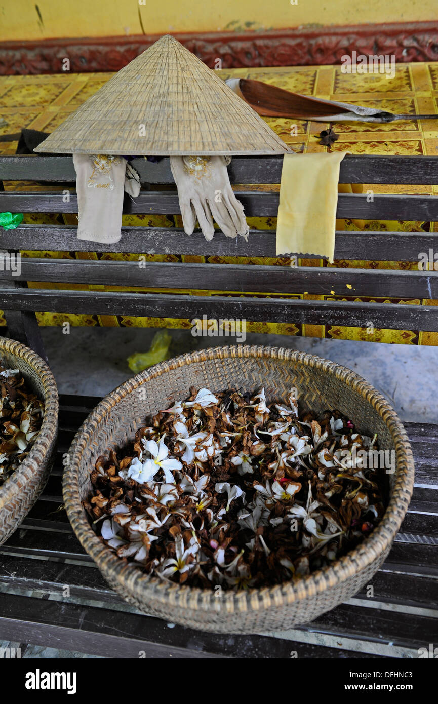 Chapeau conique traditionnel vietnamien avec des gants blancs et un roseau bol déposée auprès de fleurs séchées et d'herbes. Banque D'Images
