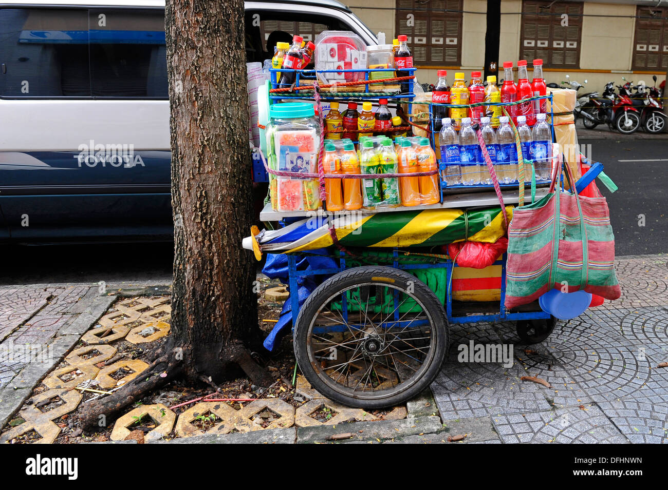 Des rafraîchissements liquides sur un panier sur le côté d'une route achalandée à Ho Chi Minh City, Vietnam. Banque D'Images