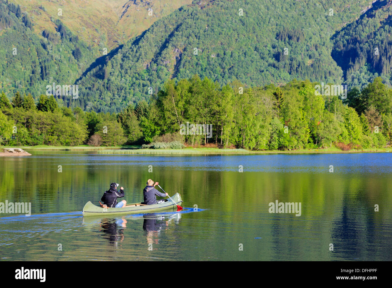 Deux hommes une pagaie canoë canadien à travers le lac Haukeland en été près de Bergen, Hordaland, Norvège, Scandinavie Banque D'Images