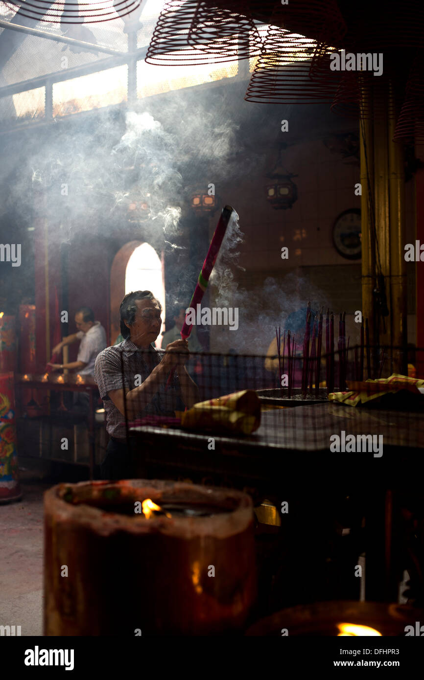 Un homme prie dans un temple chinois Banque D'Images