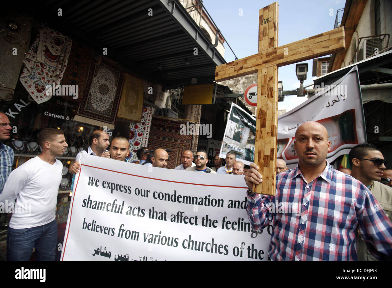 Jérusalem, Jérusalem, territoire palestinien. 6Th Oct 2013. Un manifestant palestinien est titulaire d'une croix au cours d'une manifestation contre les actes de vandalisme sur des sites chrétiens en Israël et dans les territoires occupés de Cisjordanie, à l'extérieur de la vieille ville de Jérusalem le 6 octobre 2013. La semaine dernière quatre nationalistes juifs présumés ont été arrêtés pour casser des pierres tombales dans un cimetière chrétien près de la vieille ville fortifiée de Jérusalem : Crédit Saeed Qaq/APA Images/ZUMAPRESS.com/Alamy Live News Banque D'Images