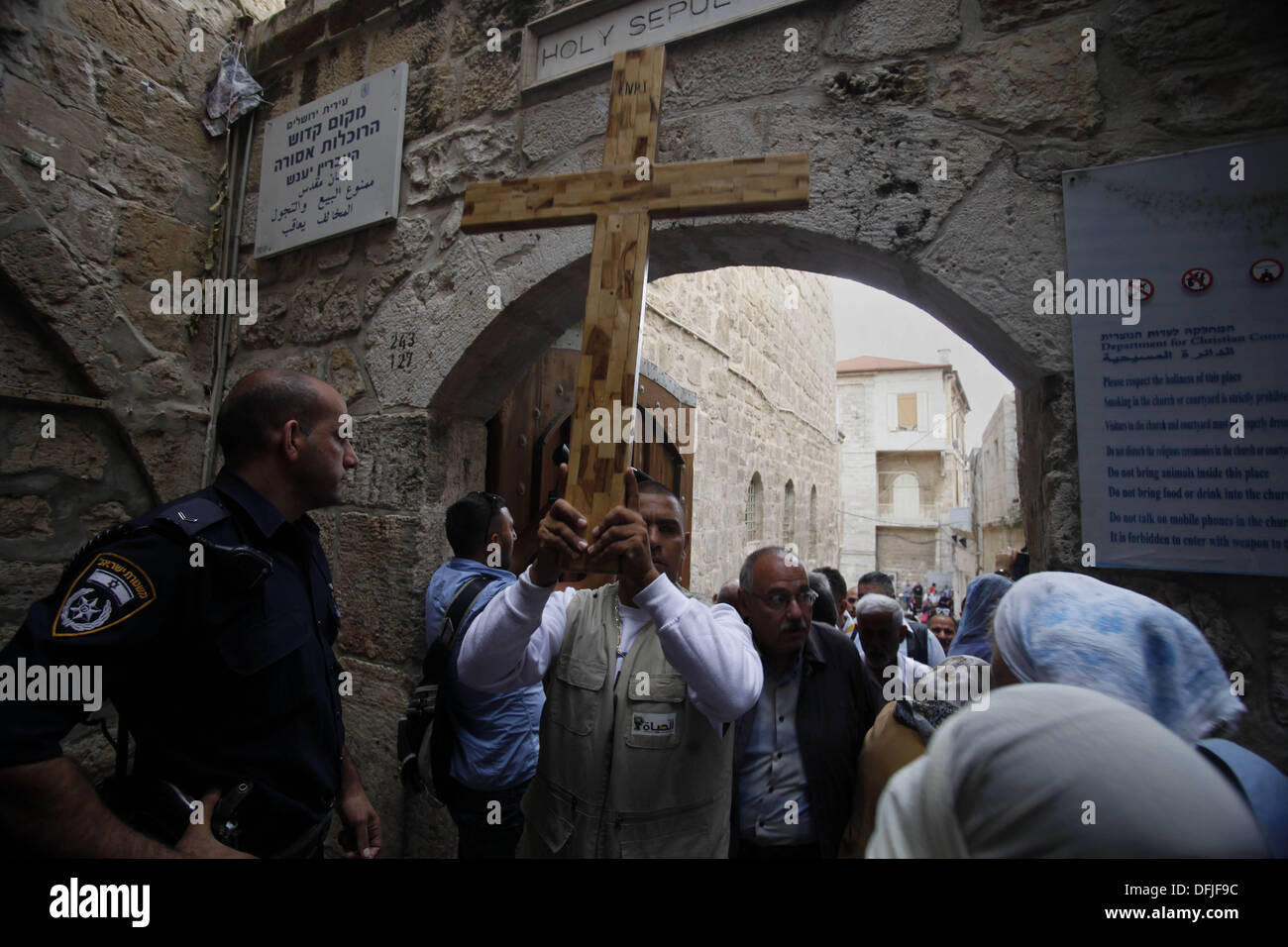 Jérusalem, Jérusalem, territoire palestinien. 6Th Oct 2013. Un manifestant palestinien est titulaire d'une croix au cours d'une manifestation contre les actes de vandalisme sur des sites chrétiens en Israël et dans les territoires occupés de Cisjordanie, à l'extérieur de la vieille ville de Jérusalem le 6 octobre 2013. La semaine dernière quatre nationalistes juifs présumés ont été arrêtés pour casser des pierres tombales dans un cimetière chrétien près de la vieille ville fortifiée de Jérusalem : Crédit Saeed Qaq/APA Images/ZUMAPRESS.com/Alamy Live News Banque D'Images