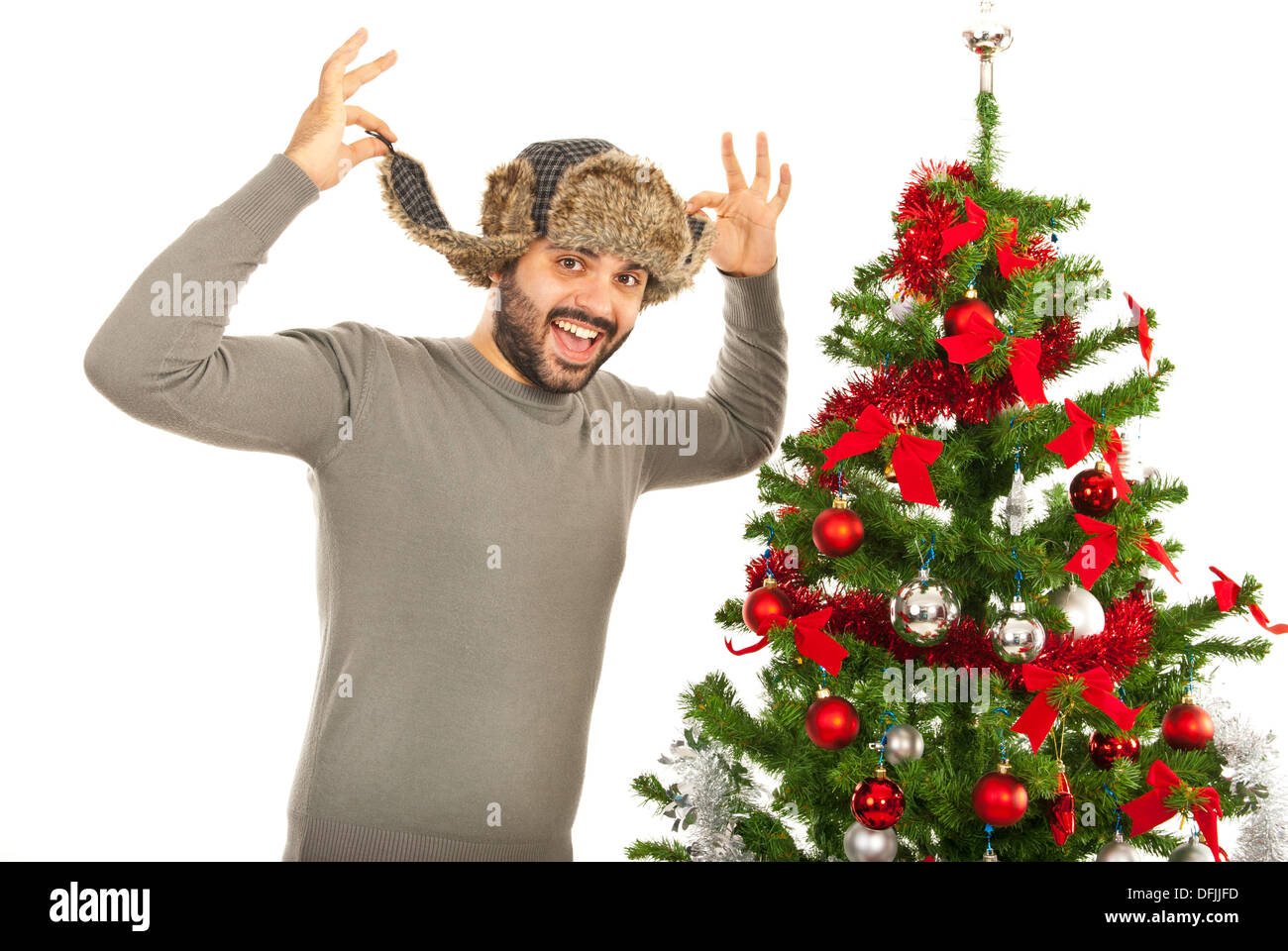 Funny man wearing fur hat et debout près de l'arbre de Noël isolé sur fond blanc Banque D'Images