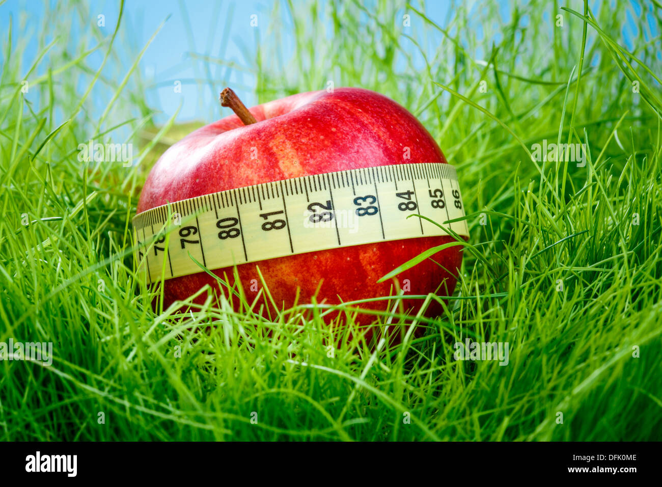 Pomme Rouge et ruban à mesurer sur l'herbe verte. Banque D'Images