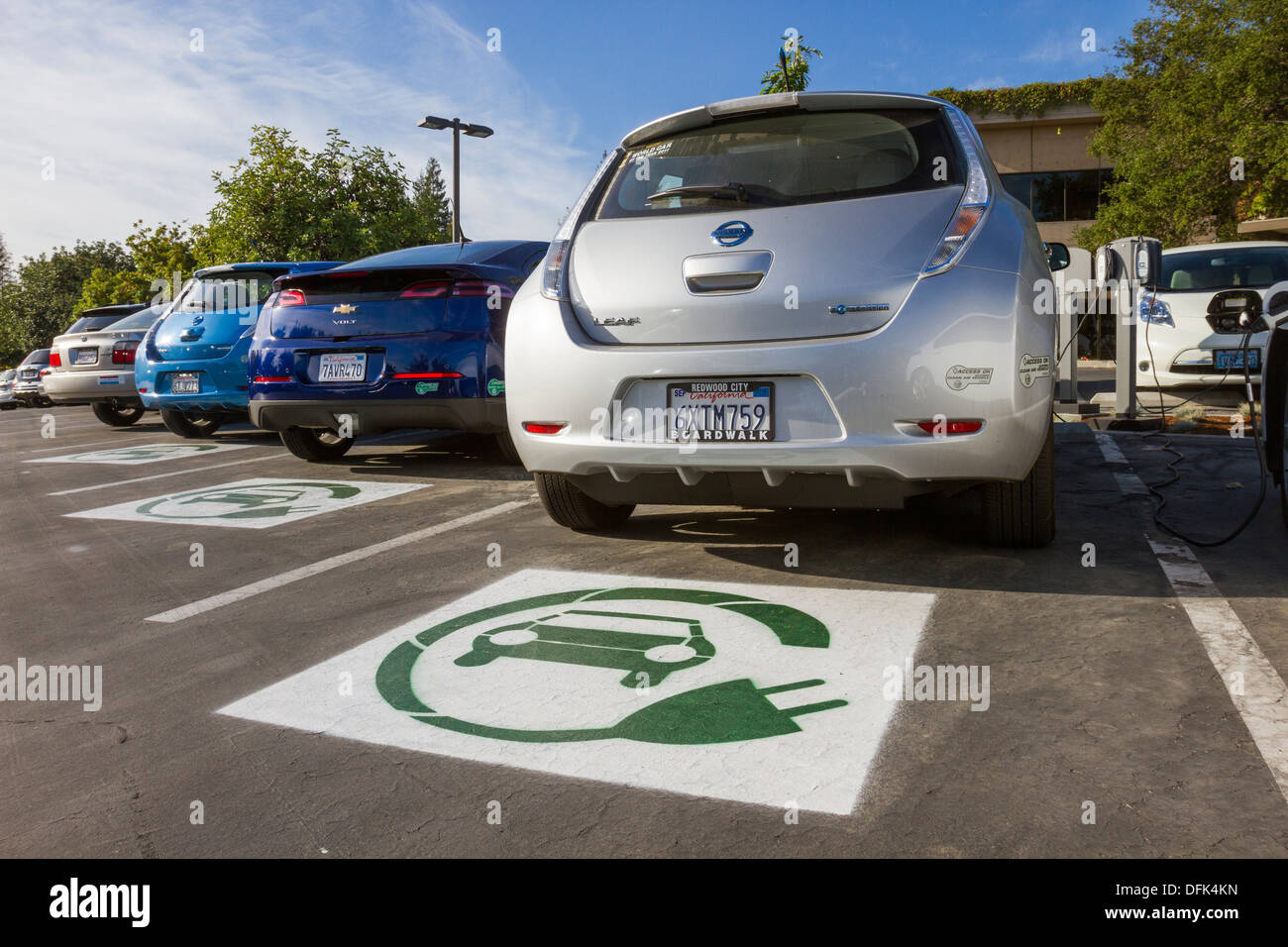 Symbole EV peint sur les espaces de stationnement réservés pour les voitures électriques dans un terrain de stationnement de l'entreprise Banque D'Images