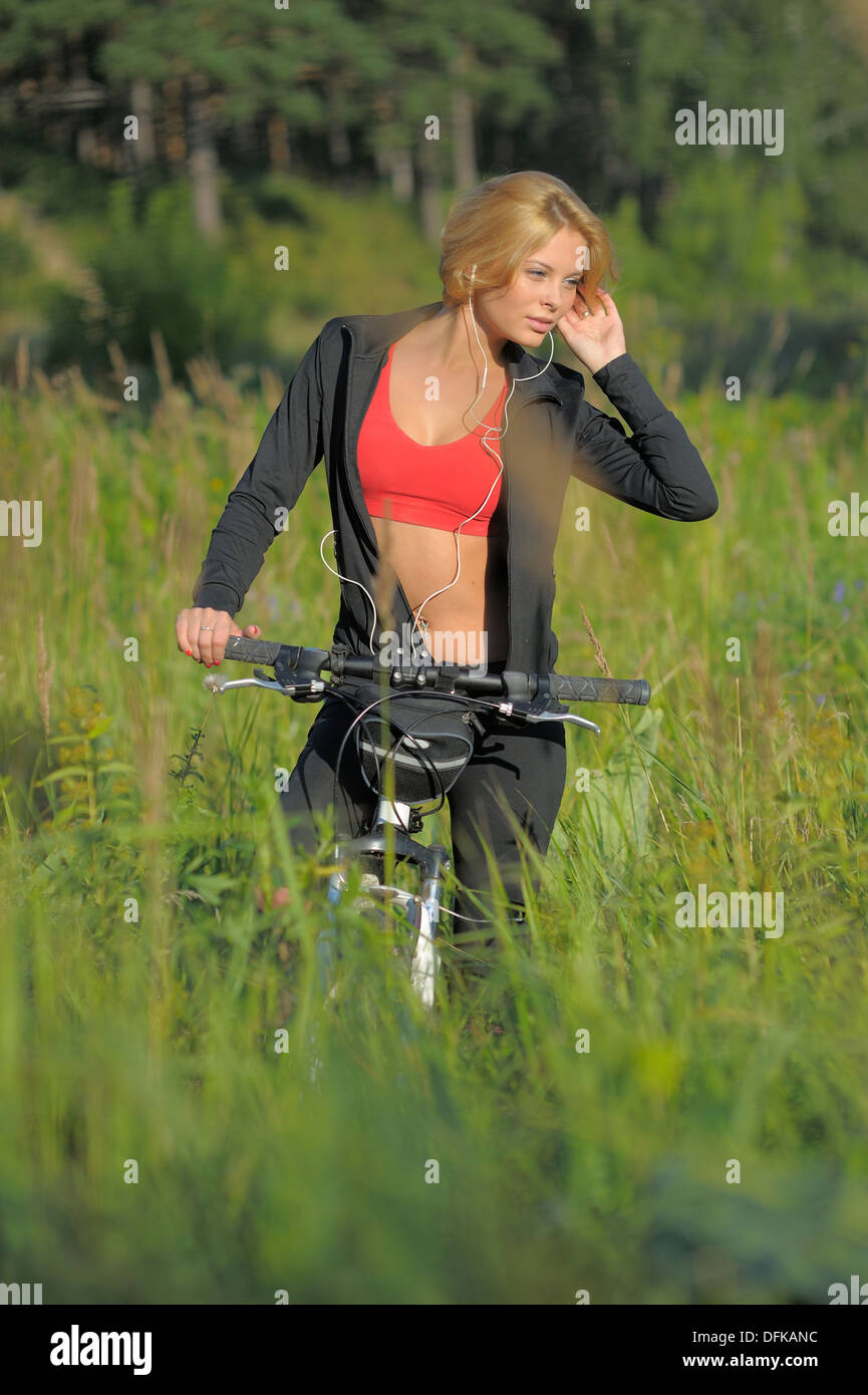 Belle jeune femme avec location d'écouter de la musique in park Banque D'Images
