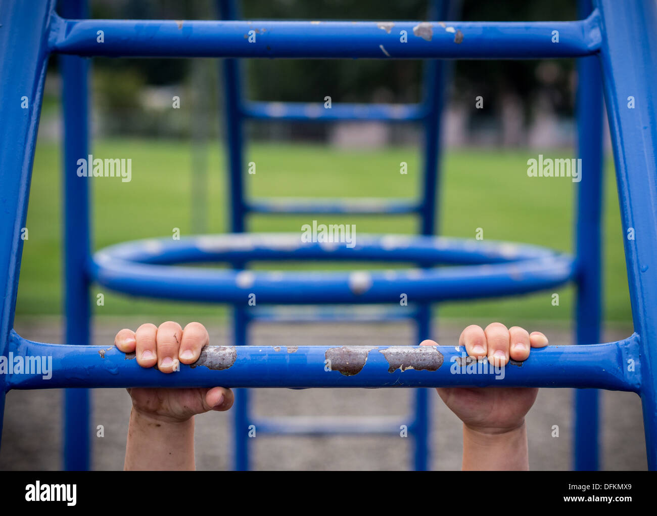 Maintenez le concept avec enfant accroché sur monkey bars Banque D'Images