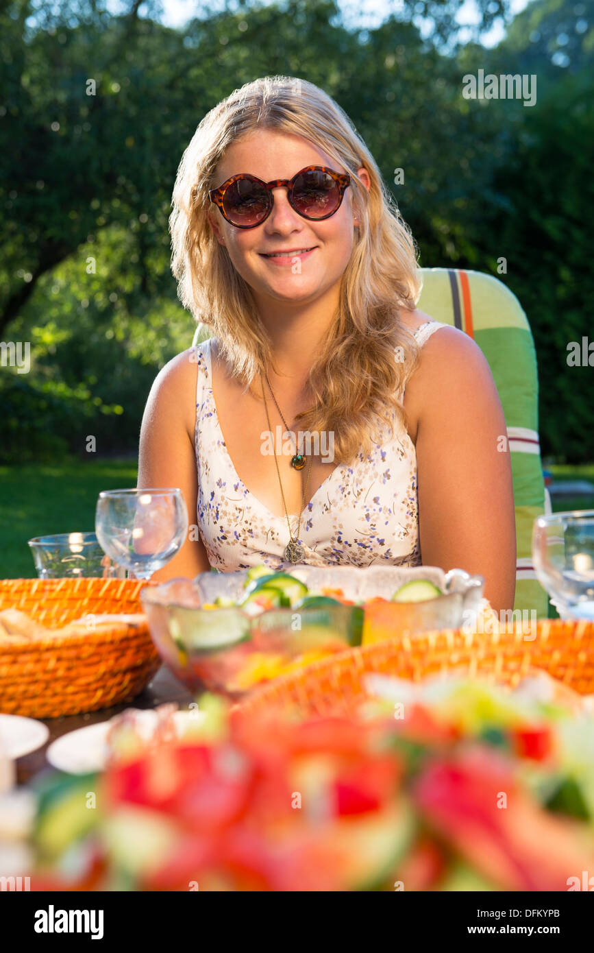 Une jeune femme bénéficiant d'une garden party sur un après-midi ensoleillé Banque D'Images