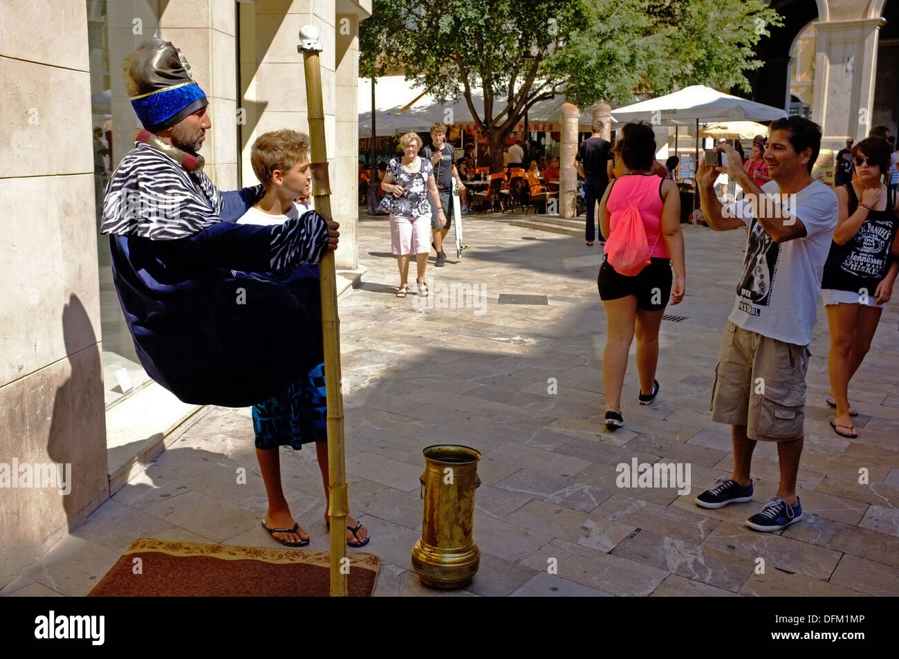 Un garçon pose pour une photo à côté d'un "fakir" à Palma, Majorque Banque D'Images