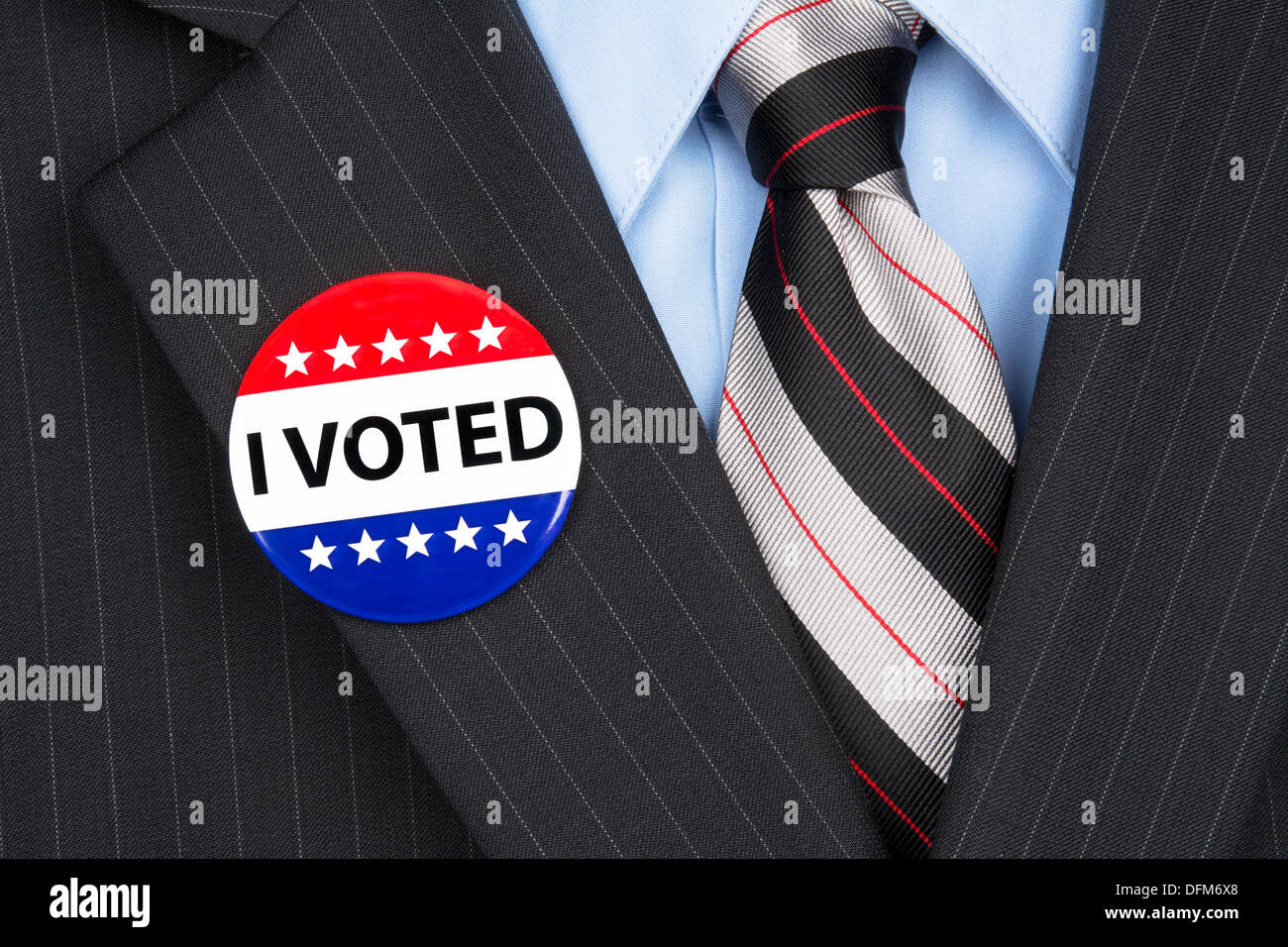 Un électeur dans sa mâle vêtu d'un costume d'affaires vote pin sur son revers. Banque D'Images