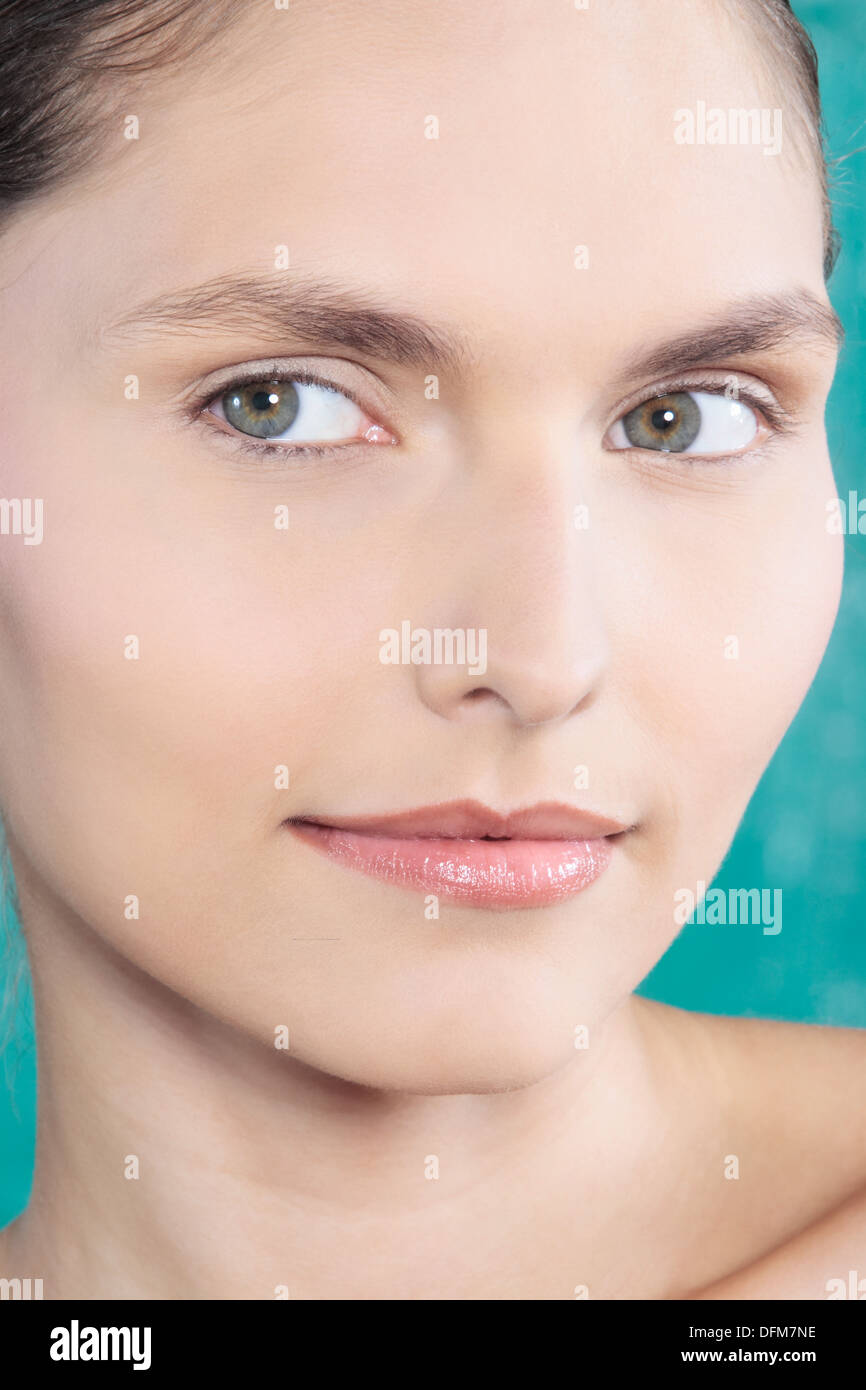 Studio shot portrait de beauté d'une belle jeune femme yeux verts sur fond bleu Banque D'Images