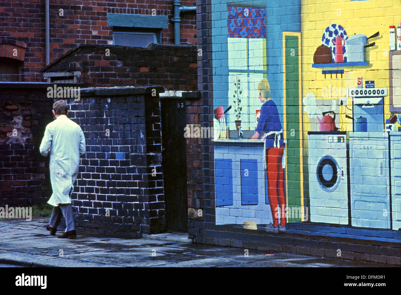 Homme marchant passé wall mural intérieur maison sur le pignon d'une maison de Rochdale Lancashire UK 1975 KATHY DEWITT Banque D'Images