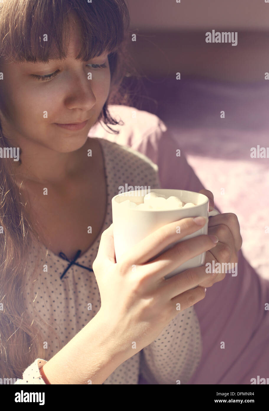 Jeune fille et une tasse de chocolat chaud avec des guimauves dans la matinée Banque D'Images