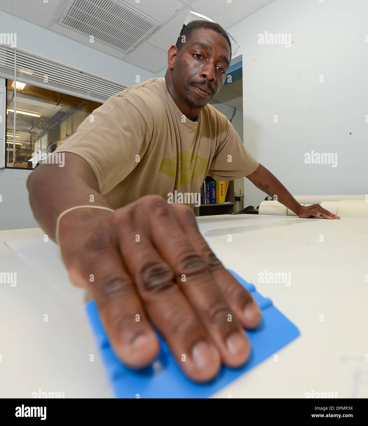 M. Antoine Robinson du 436e Escadron de maintenance des aéronefs, le contrôle de la Corrosion boutique, appuie le cadre d'un autocollant pour le papier transfert sur Septembre 9, 2013 à Dover Air Force Base, Del. Le autocollant sera appliquée à une partie d'avions en métal pour faire un m Banque D'Images