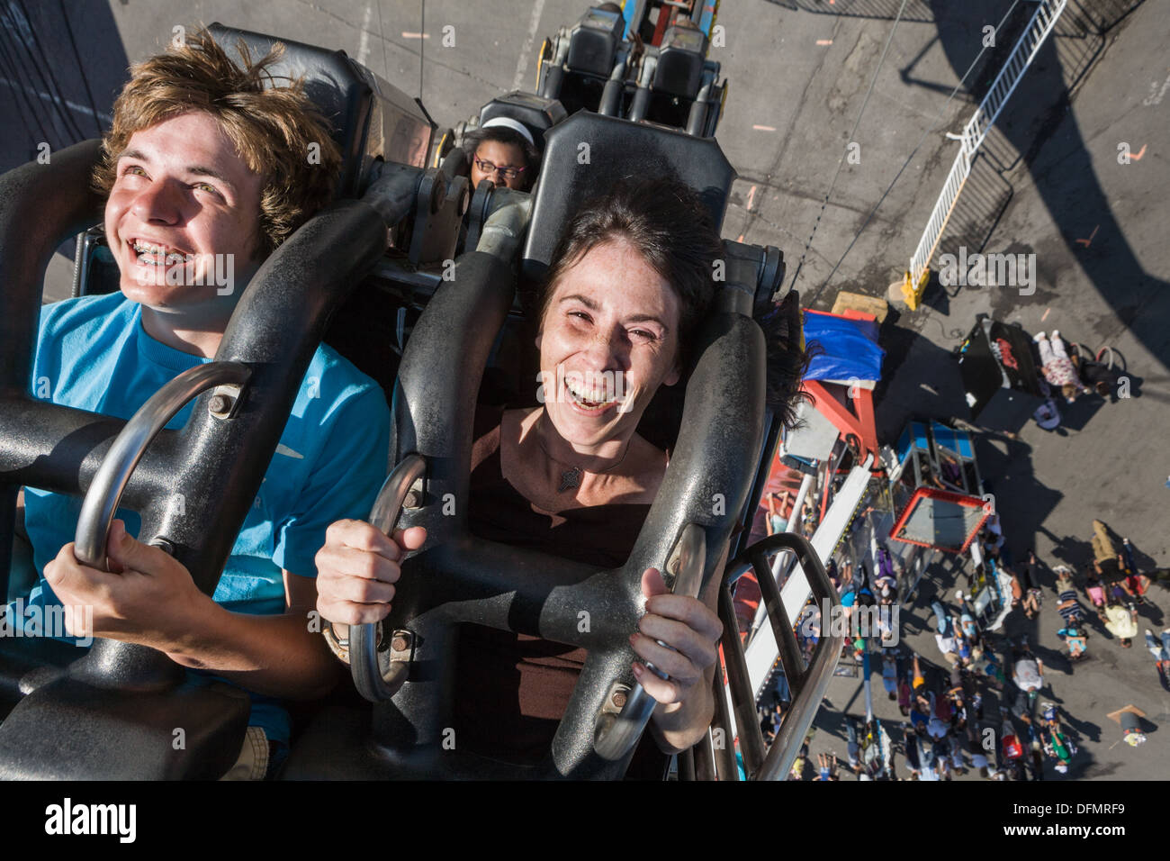 La mère et le fils à l'envers sur les sensations fortes, une grande foire de l'État de New York. Banque D'Images