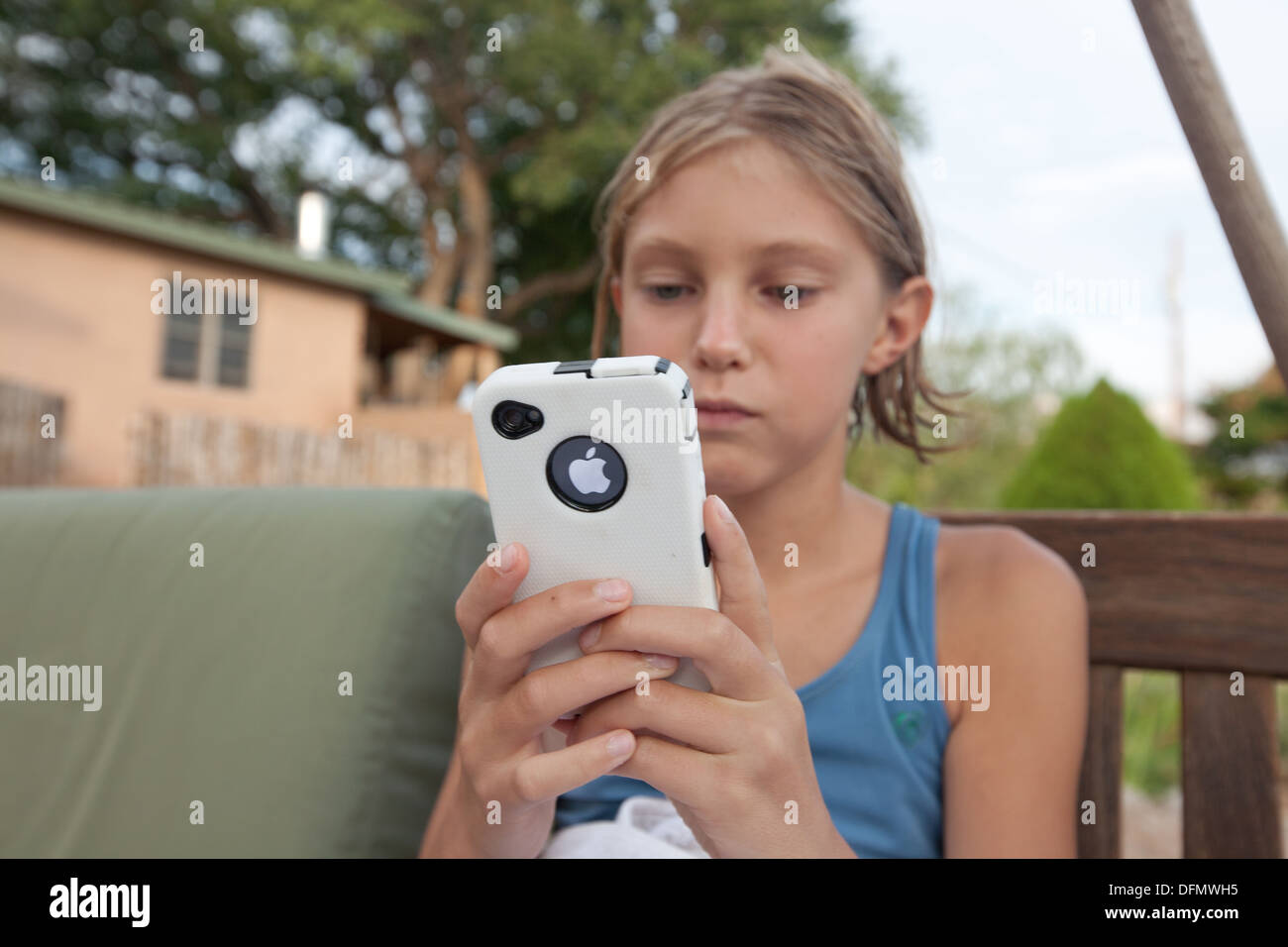 Dix ans, fille tenant un iphone avec un boîtier étanche. Banque D'Images