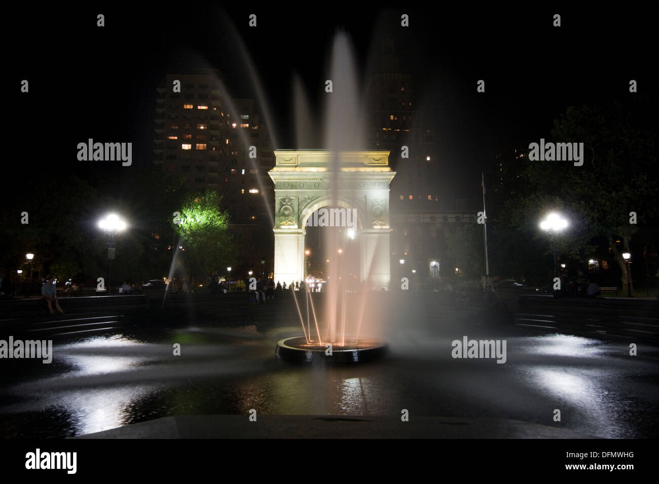 New York City's Washington Sq Parc de la fontaine illuminée la nuit avec la 5e Avenue, visible à travers l'arche Banque D'Images