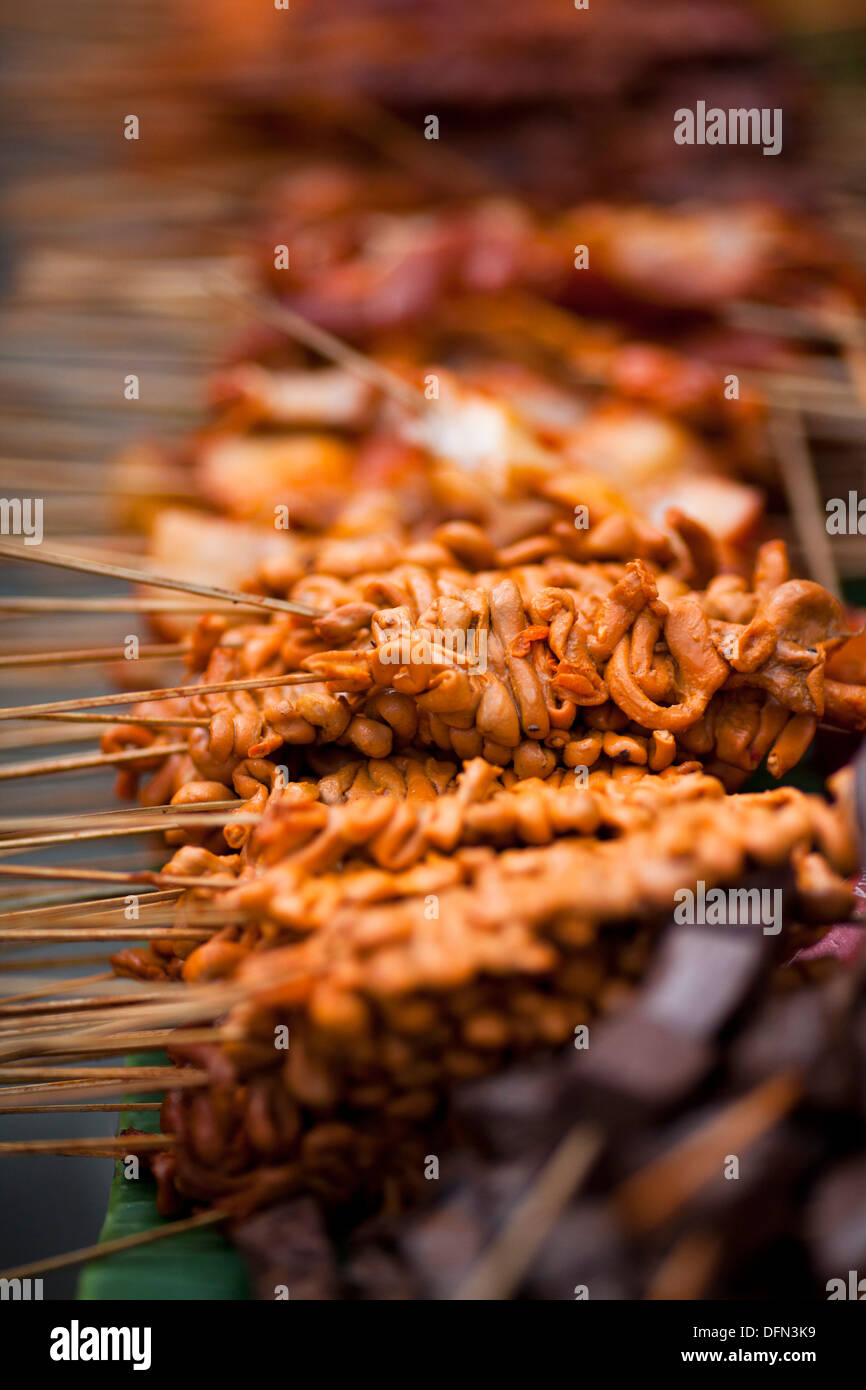 Parties de poulet brochette de bâtons sur un street food vendor's panier à Baclaran, Manille, Philippines. Banque D'Images