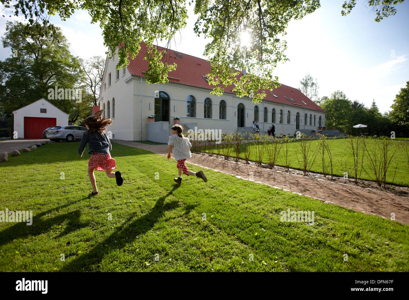 Les enfants courent sur une prairie près d'un hôtel, Fincken, Mecklembourg-Poméranie-Occidentale, Allemagne Banque D'Images