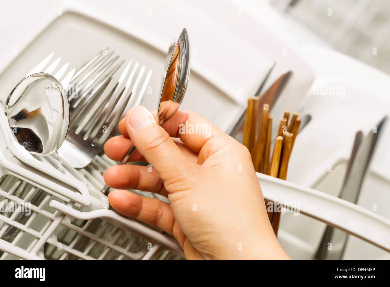 Main de femme de photo horizontale en acier inoxydable cuillère pour l'examen de la propreté lave-vaisselle Banque D'Images