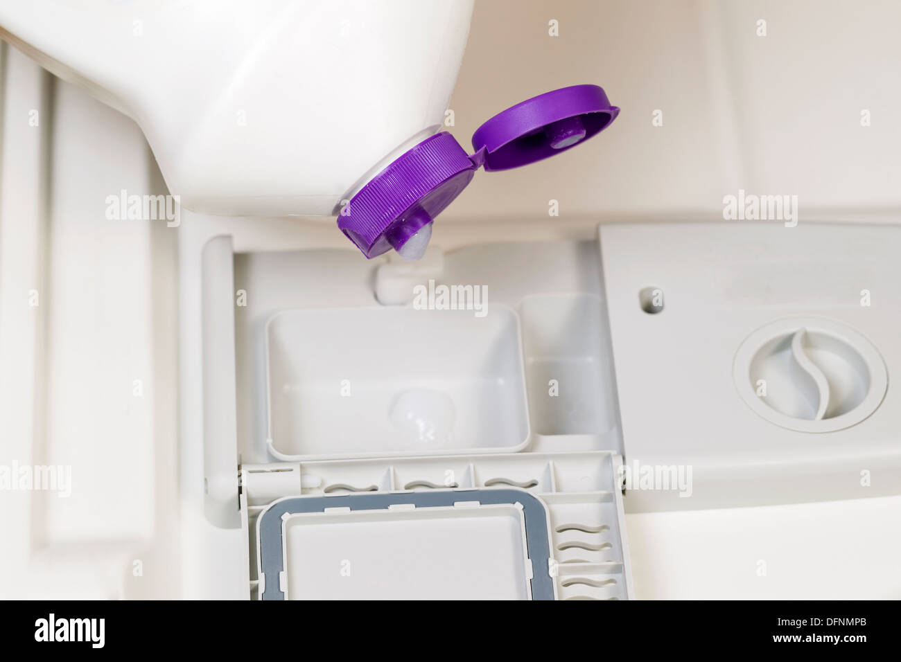 Photo horizontale de détergent est versé dans un distributeur de savon lave-vaisselle Banque D'Images
