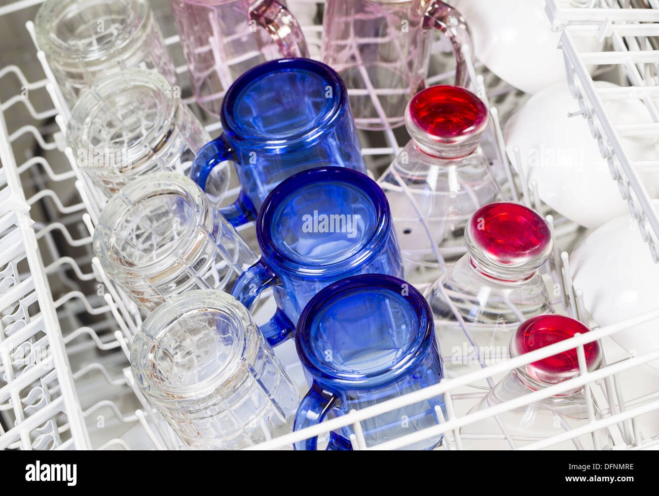 Photo horizontale de lave-vaisselle chargé avec bleu, rouge, rose clair et blanc lunettes avec verres Banque D'Images