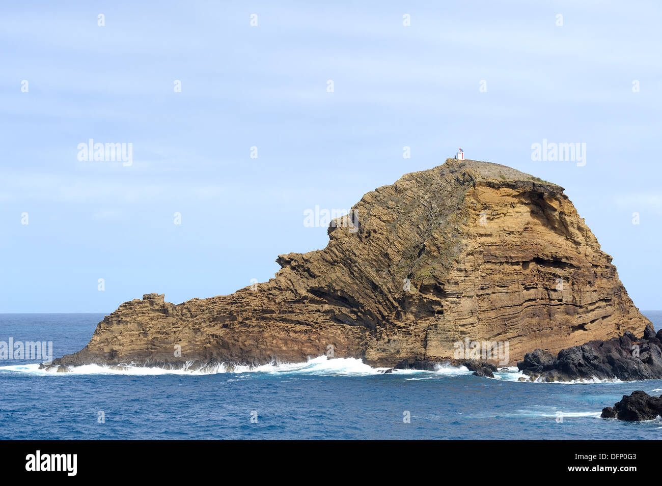 Porto Moniz Madère une petite île rocheuse Islote pier avec petit phare sur elle's Peak Banque D'Images