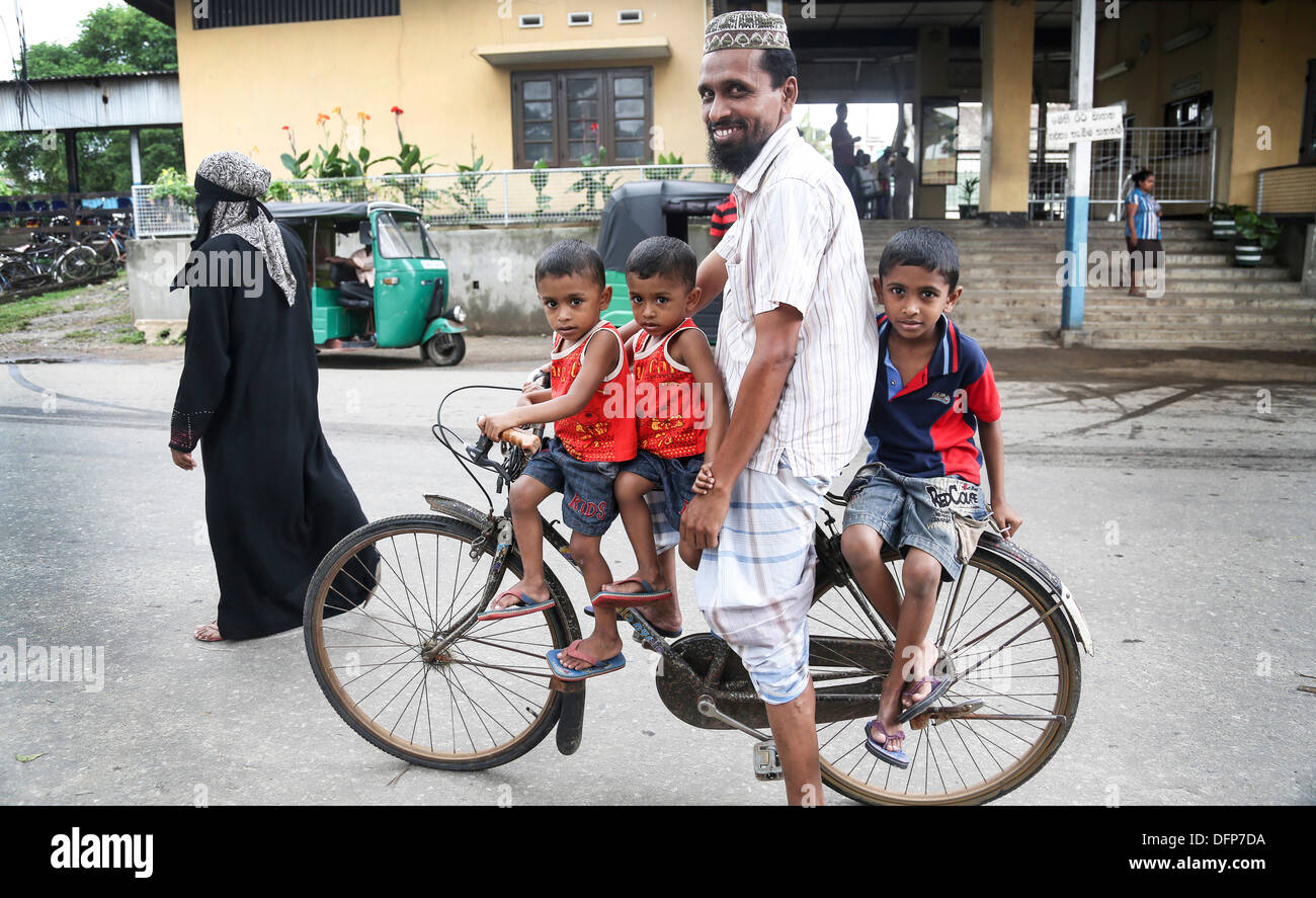 Papa sur vélo avec trois fils cute boys school run Banque D'Images